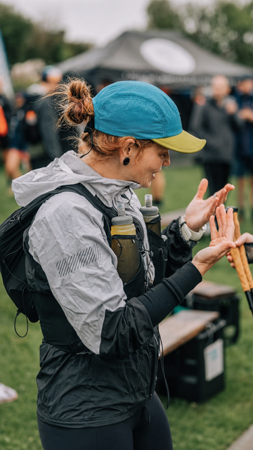 Trail runner wearing a lightweight cap and hydration vest at an outdoor event