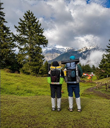 Two hikers wearing ultralight backpacks in an alpine mountain camp setting
