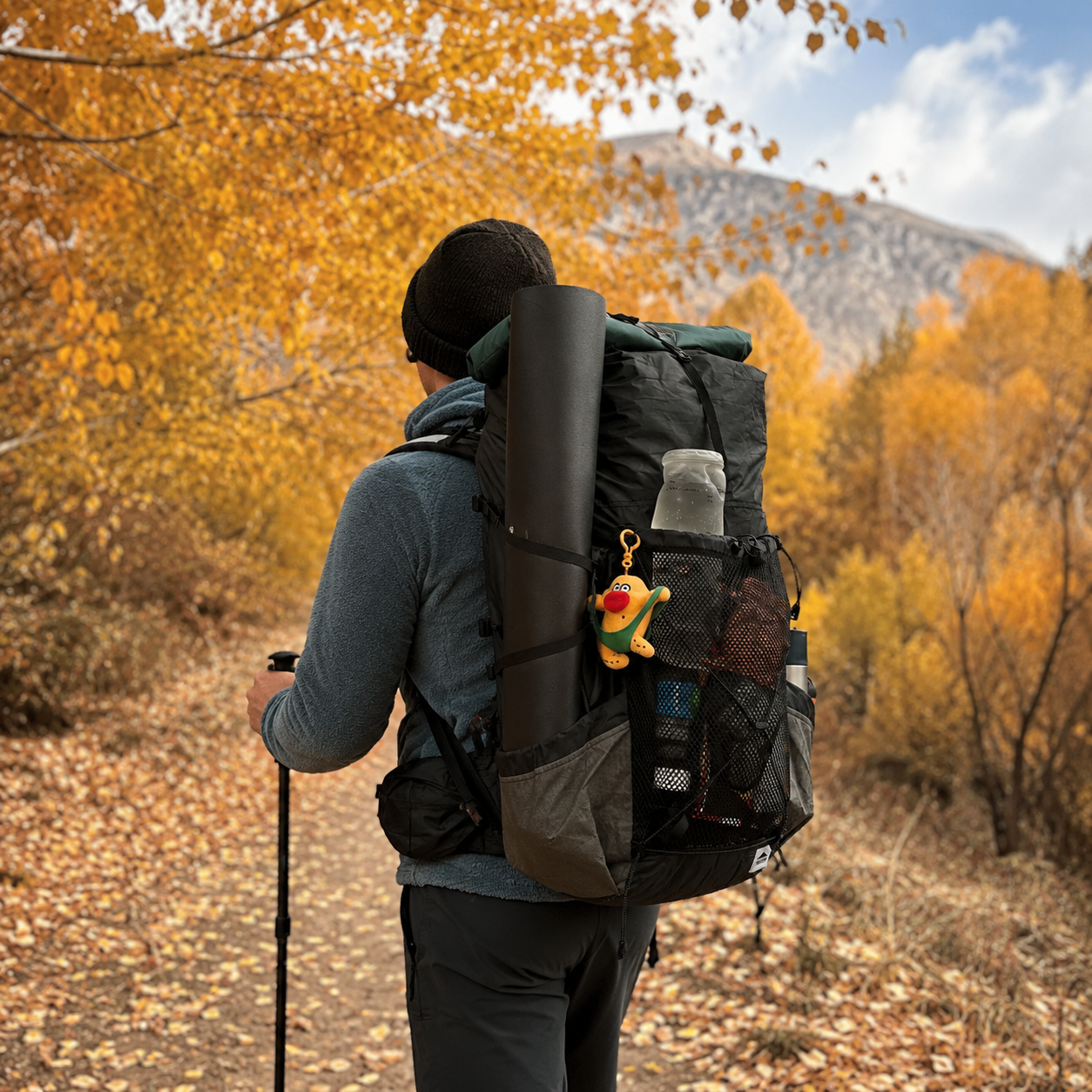 Lightweight black foam ground mat carried on backpack for autumn hiking