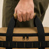Hand carrying khaki camping bag with padded grip and black webbing handles