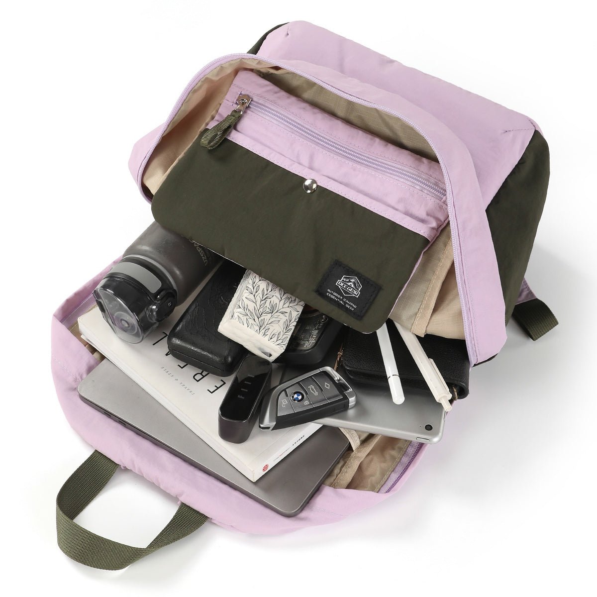 Open backpack with daily carry items, front organizer pouch, and beige lining visible