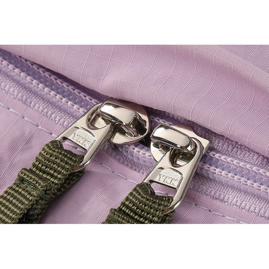 Close-up of metal zipper sliders with olive webbing zipper pulls