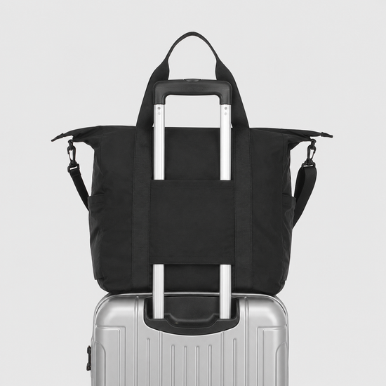 Packable travel tote bag mounted on suitcase handle with luggage sleeve