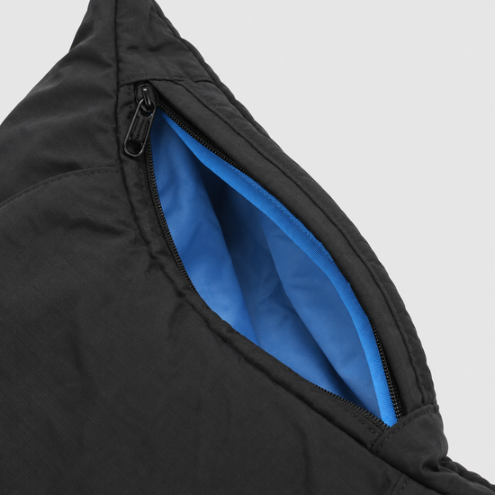 Side zipper expansion detail on black blue crescent bag