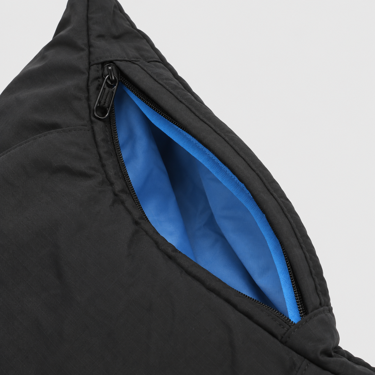 Side zipper expansion detail on black blue crescent bag